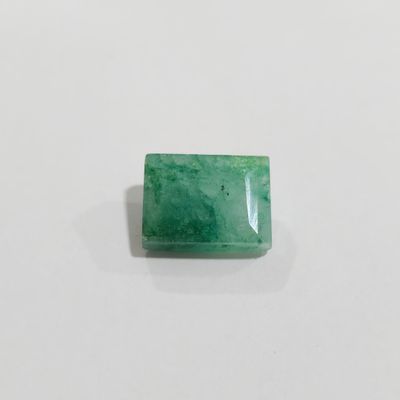 a green emerald stone on a white surface