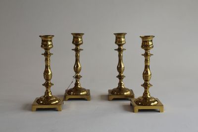 three brass candlesticks on a white background with a white background
