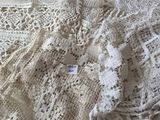 un châle blanc au crochet posé sur un lit