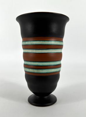 a black vase with brown and blue stripes on it