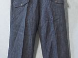 grey pants hanging on a hanger on a white wall