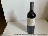 une bouteille de vin posée sur une table, sur fond blanc