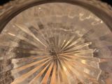 a glass bowl with a lid that has a flower design on it