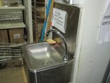 a stainless steel sink in the corner of a room