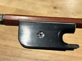 a violin bow with a wooden handle on a wooden table
