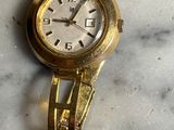 une montre-bracelet en or posée sur une surface en marbre