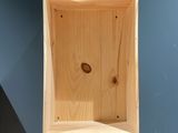 une boîte en bois percée d'un trou, accrochée au mur