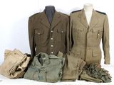 trois uniformes militaires exposés sur une table blanche