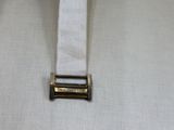 a close up of a white belt with a metal buckle