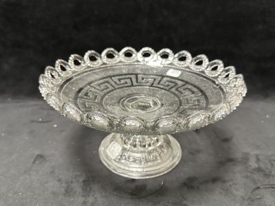une image représentant un saladier en verre posé sur une table, sur fond noir
