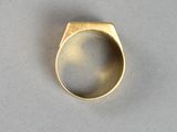 a close up of a gold ring on a white surface