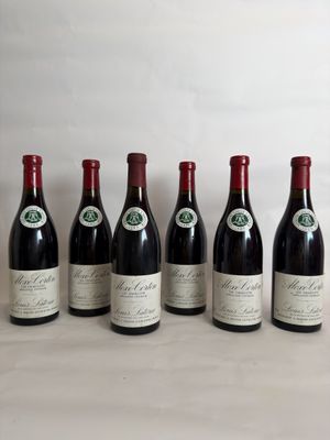 six bottles of wine are lined up in a row on a table