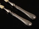 two silver spoons on a black table with a black background