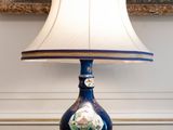 a lamp that is sitting on a table in front of a painting