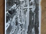 a black and white photo of a train going down the tracks