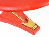 a close up of a red chair with a gold handle