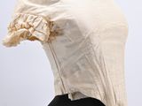 the back of a mannequin dress with a white blouse and black pants