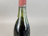 a bottle of wine that has a red cap on it