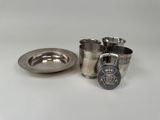une tasse et un plateau en argent sur une table blanche