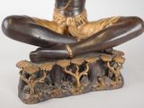 a statue of a woman sitting on top of a rock