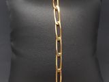 a gold plated bracelet on a black pillow