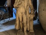 a statue of a man that is standing next to a vase