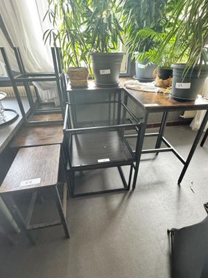 des tables et des chaises dans une pièce où se trouve une plante sur le rebord de la fenêtre