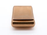 an image of a gold cigarette case sitting on a white surface