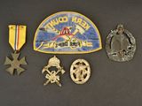 several badges and medals are displayed on a black surface