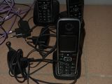 trois téléphones portables posés par terre à côté d'un numéro