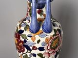 a vase with a blue handle on it on a table