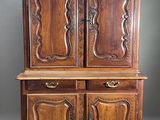 a wooden cabinet with two doors and a drawer on top of it