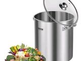 a large pot with a lid next to a pile of vegetables