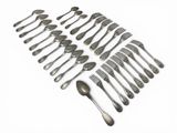 a lot of spoons and forks laid out on a white surface
