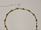 a close up of a gold bracelet on a white surface