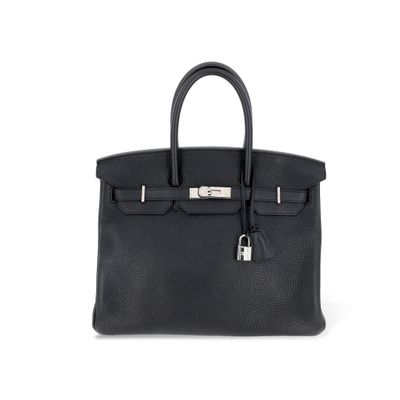 un sac à main en cuir noir sur fond blanc