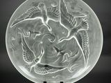 une plaque de verre ornée d'un motif représentant un oiseau et un poisson