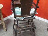 a wooden high chair in a room with a red wall