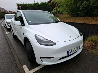 a white tesla car parked on the side of the road