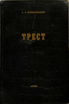 an old book sitting on top of a wooden table next to a white wall