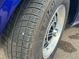 un gros plan d'un pneu sur une voiture bleue