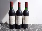 trois bouteilles de vin posées sur une table l'une à côté de l'autre