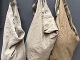 trois sacs suspendus à un crochet fixé au mur