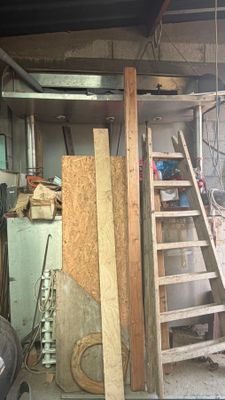 une photo d'un garage avec une échelle et un tas de bois