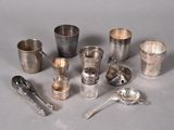 a lot of silver cups and spoons sitting on a table