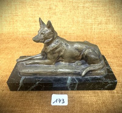 statue d'un chien posée sur un socle en marbre, sur lequel est accrochée une étiquette