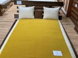 un lit recouvert d'une couverture jaune