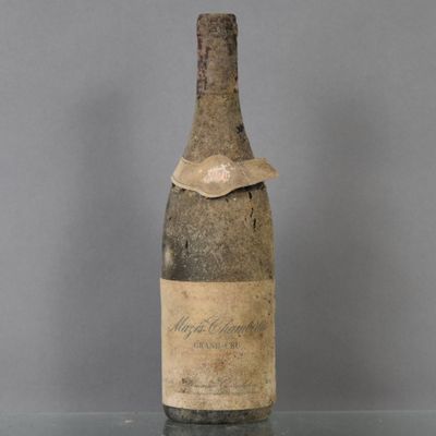 an old bottle of wine sitting on top of a glass table