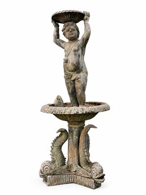 une statue représentant un garçon tenant un bol au-dessus d'un bain d'oiseaux