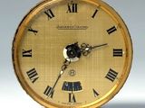 une horloge en or avec des chiffres romains sur le cadran